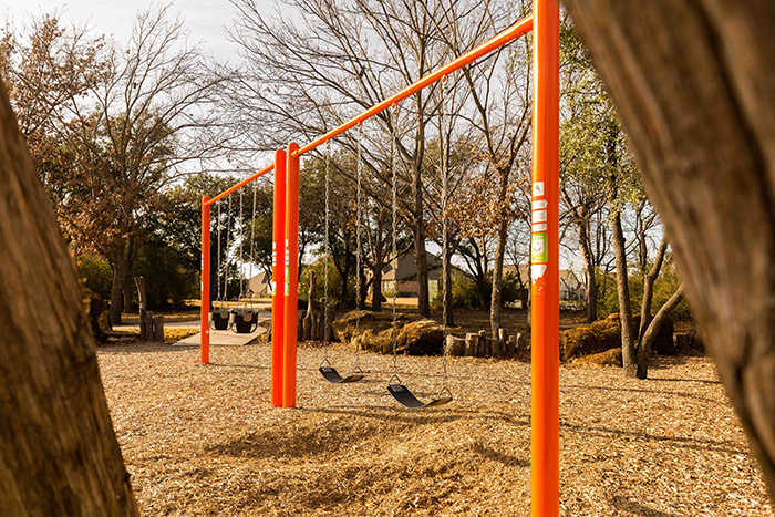 The natural playground offers a swing set for children of all ages to enjoy.